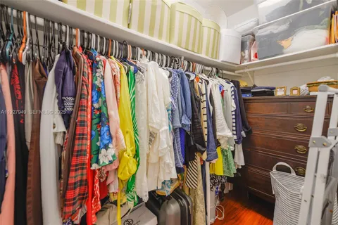 a view of walk in closet with clothes and shoes