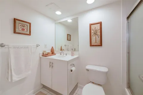 a bathroom with a toilet a sink a mirror a vanity and window