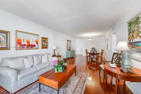 a living room with furniture kitchen view and a window