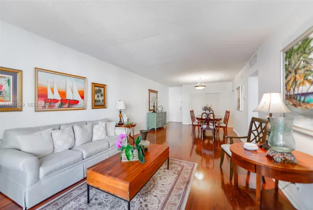 a living room with furniture kitchen view and a window