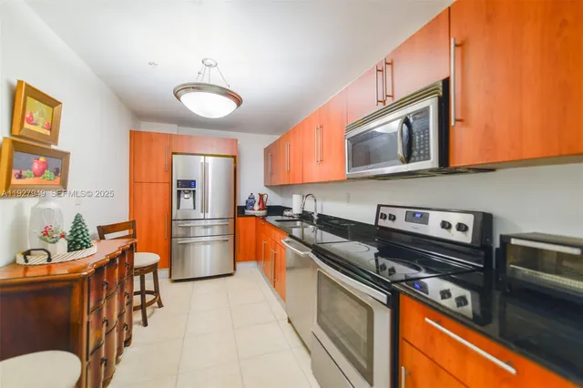 a kitchen with stainless steel appliances granite countertop a stove a sink dishwasher and cabinets with wooden floor