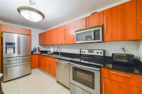 a kitchen with stainless steel appliances granite countertop a stove microwave and sink