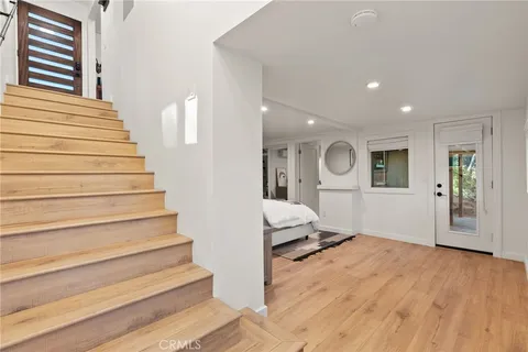 a view of a hallway with wooden floor and staircase