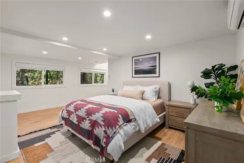 a bedroom with a large bed and a potted plant