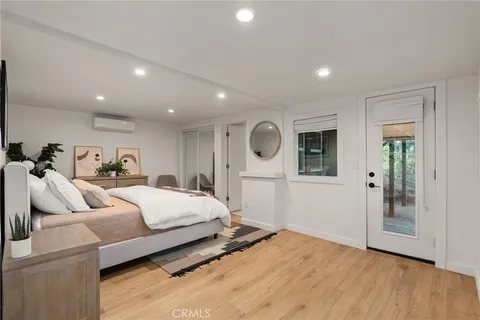 a spacious bedroom with a bed and wooden floor