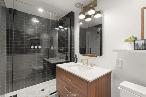 a bathroom with a sink shower and a mirror