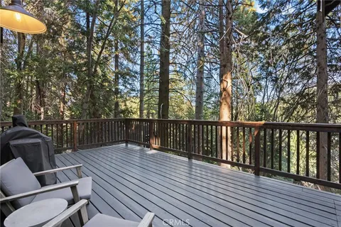 a balcony with wooden floor and outdoor seating