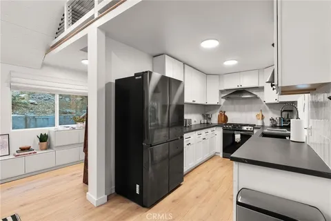 a kitchen with a refrigerator a stove top oven a sink and dishwasher with wooden floor