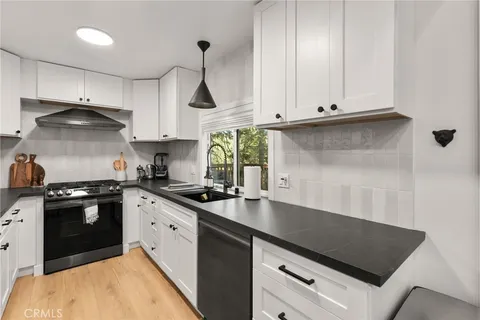 a kitchen with stainless steel appliances granite countertop a sink stove and cabinets