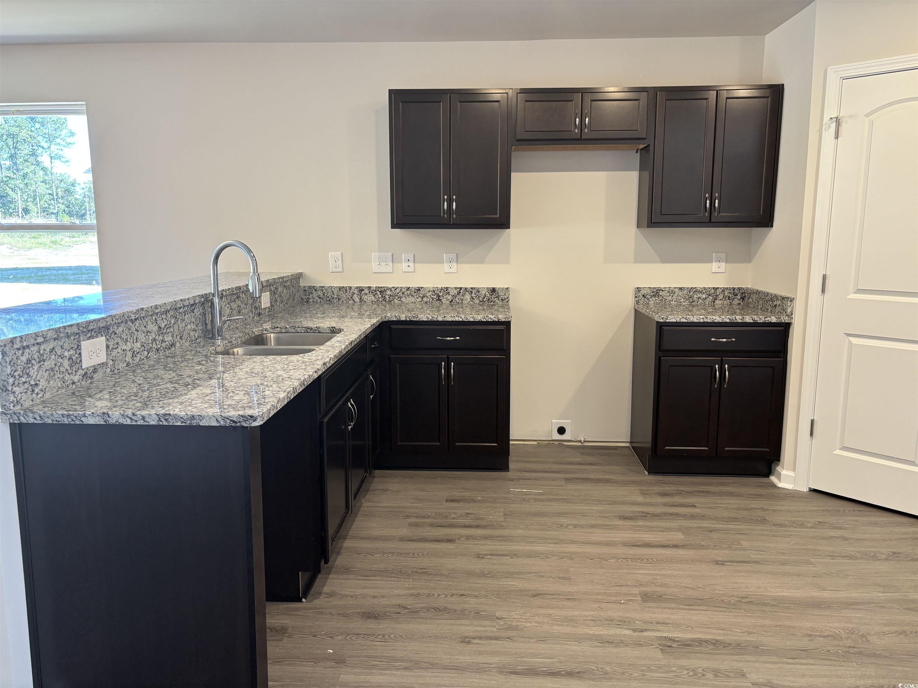 5729 Highway 41 Marion, SC 29571 - Photo 3 of 8 Kitchen featuring light stone countertops, light wood-style floors, and a peninsula