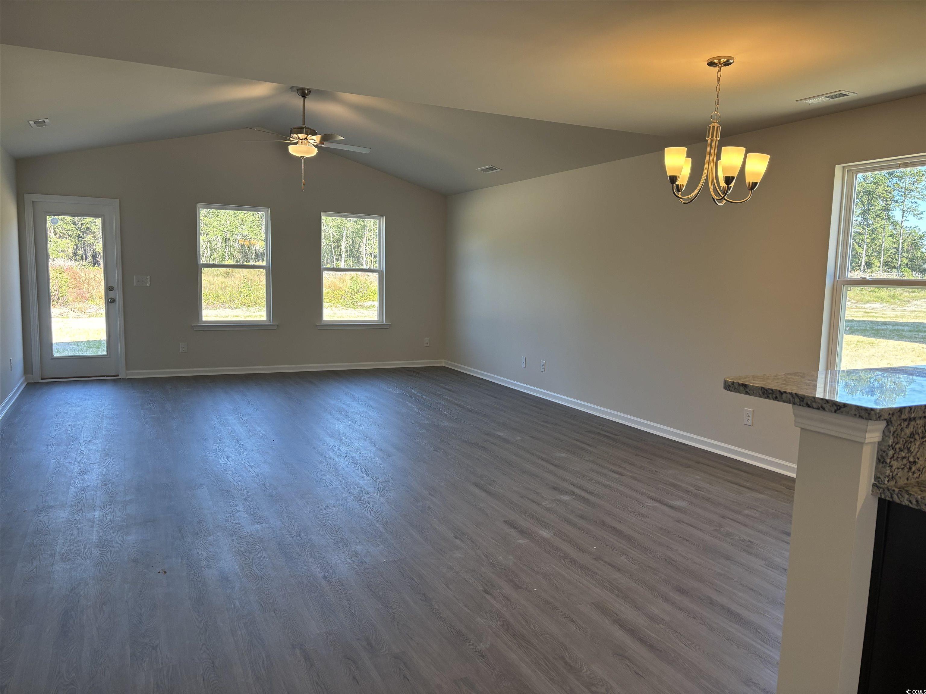 5729 Highway 41 Marion, SC 29571 - Photo 4 of 8 Unfurnished living room featuring lofted ceiling, healthy amount of natural light, and dark wood finished floors