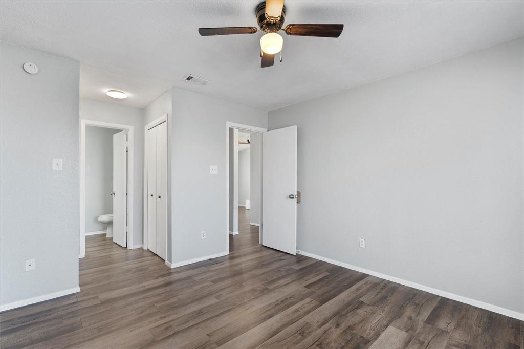 1711 Rawhide Loop Round Rock, TX 78681 - Photo 7 of 14 Unfurnished bedroom featuring dark wood-style floors, ceiling fan, and a closet
