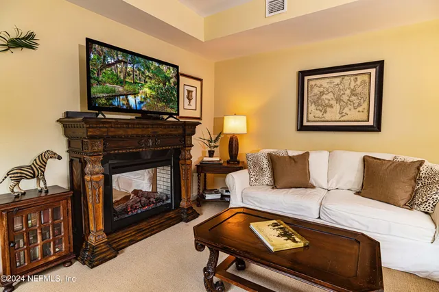 a living room with furniture a flat screen tv and a fireplace