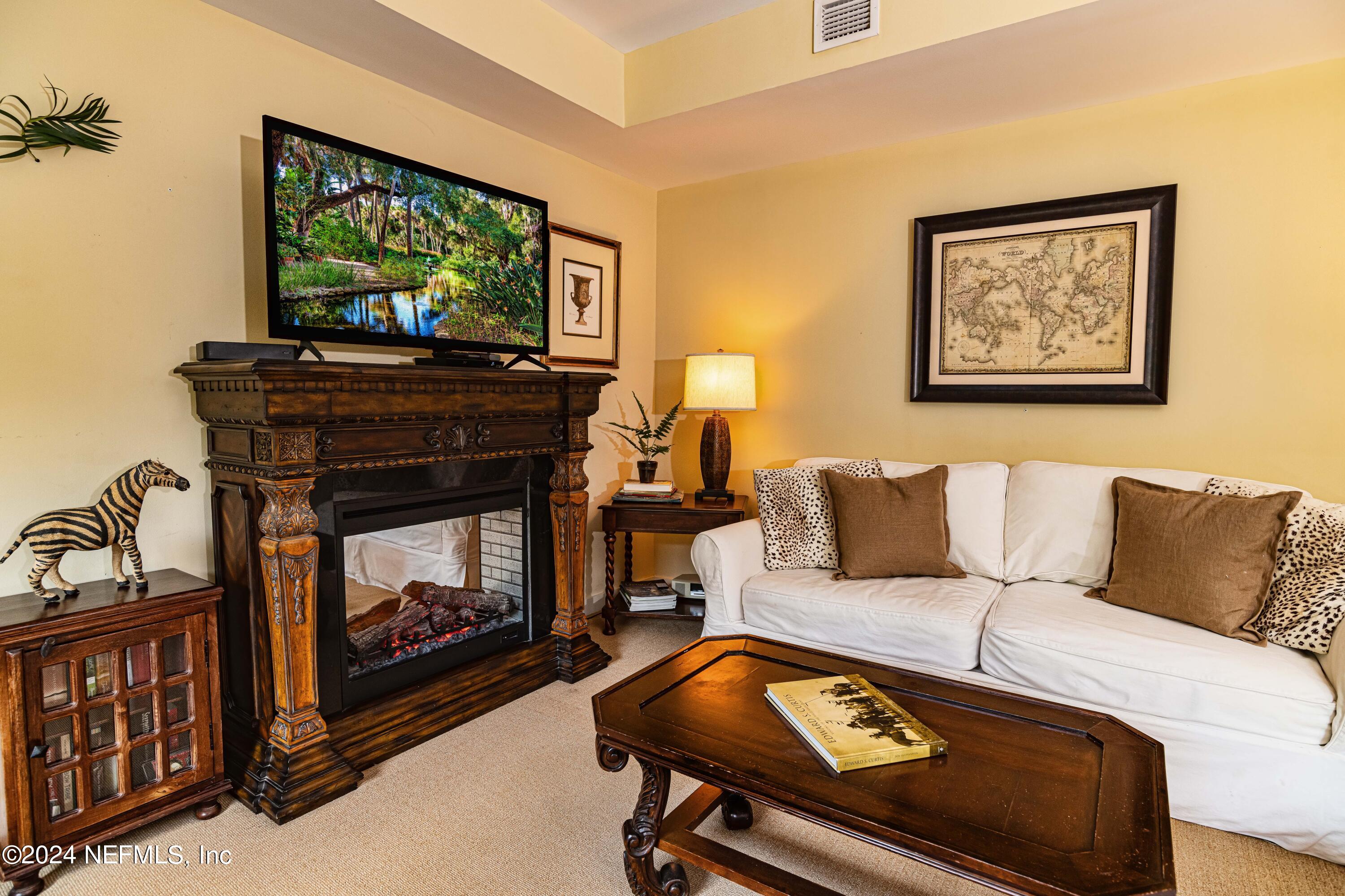 955 Registry Boulevard, Unit 229 St. Augustine, FL 32092 - Photo 14 of 36 a living room with furniture a flat screen tv and a fireplace