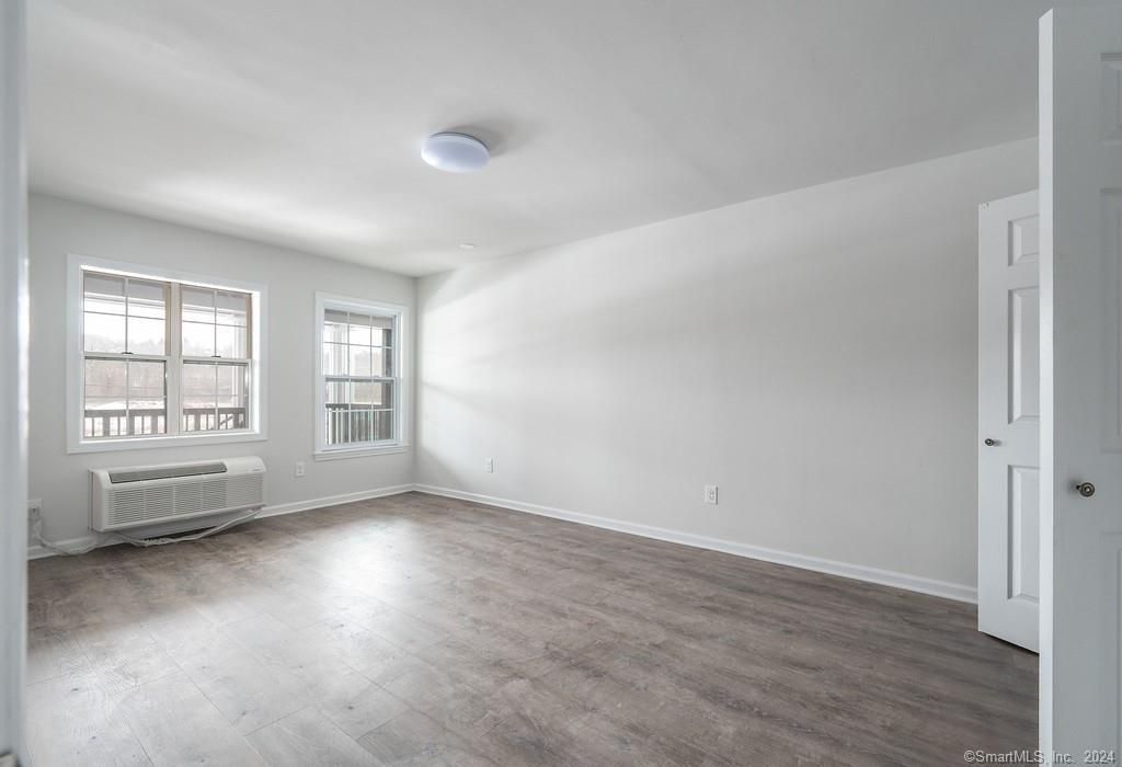 1030 Federal Road, Unit 201 Brookfield, CT 06804 - Photo 13 of 20 an empty room with wooden floor and windows