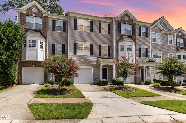 a front view of a house with yard and green space
