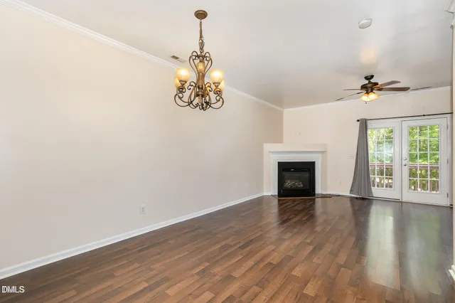 a view of a livingroom with a chandelier wooden floor and a chandelier