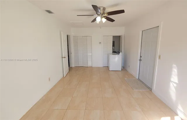 a view of a big room with wooden floor and a chandelier fan