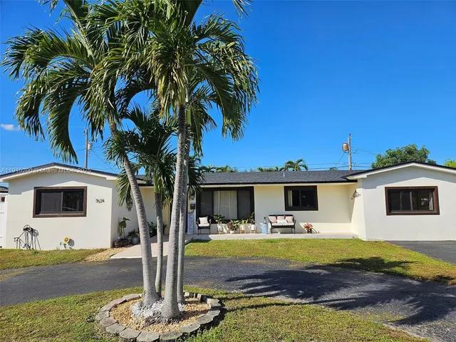 a front view of a house with garden and swimming pool