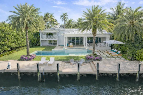 a view of a house with pool and chairs