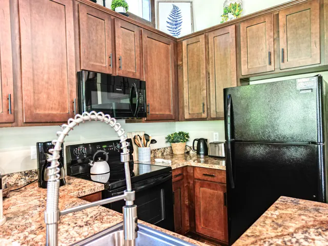 a kitchen with stainless steel appliances granite countertop a refrigerator and a stove top oven