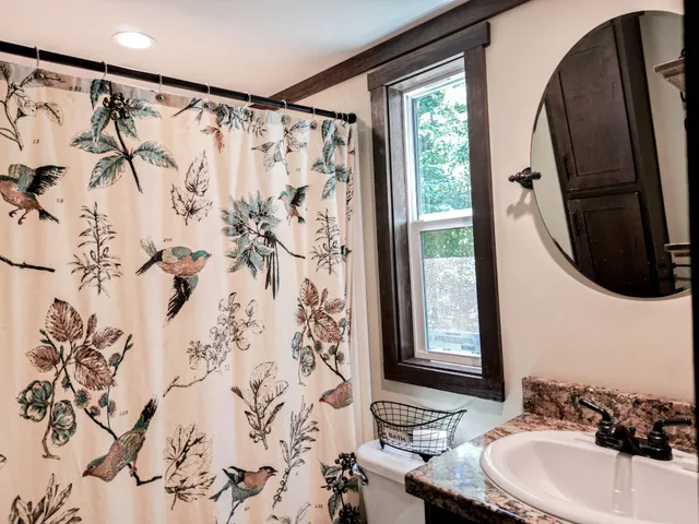 a bathroom with a sink and mirror with bathtub