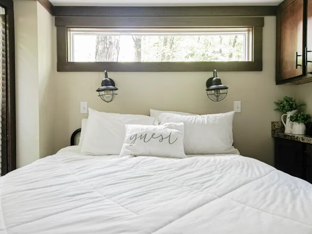 a bedroom with a bed and a potted plant on dresser