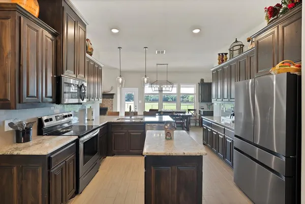 a kitchen with lots of counter top space a sink appliances and cabinets