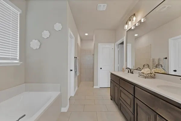 a bathroom with a tub sink and mirror
