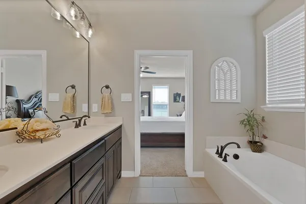 a bathroom with a tub sink and mirror
