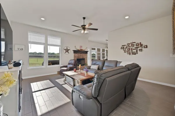 a living room with furniture large window and flat screen tv