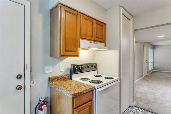 a kitchen with stainless steel appliances granite countertop a sink a refrigerator and cabinets with wooden floor