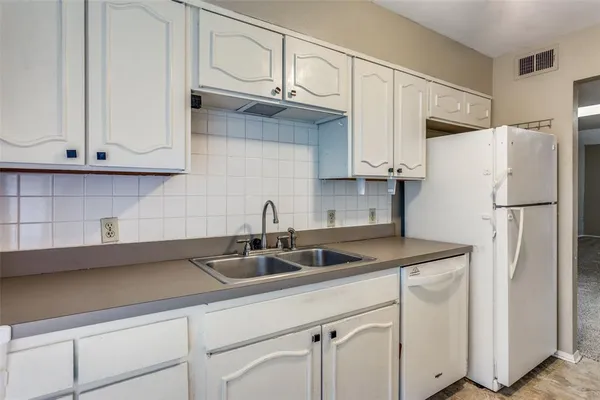 a kitchen with a sink a stove and cabinets