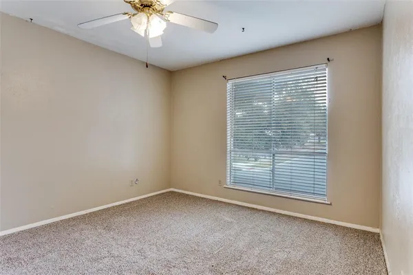 a view of an empty room and chandelier fan