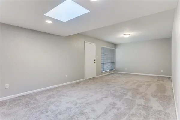 an empty room with a window and a ceiling fan