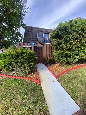 a backyard of a house with table and chairs under an umbrella