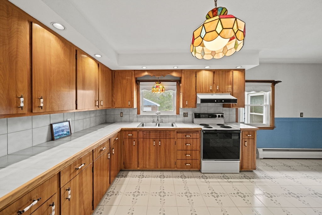 7 Cedarcrest Road Salem, MA 01970 - Photo 10 of 41 a large kitchen with stainless steel appliances granite countertop a stove a sink and a microwave