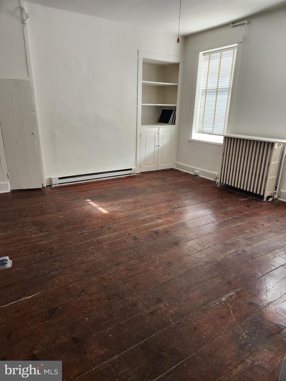 114 South Princess Street, Unit 1 Shepherdstown, WV 25443 - Photo 2 of 10 an empty room with wooden floor and windows