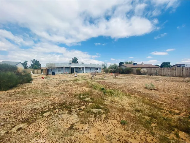 a view of a big yard with wooden fence