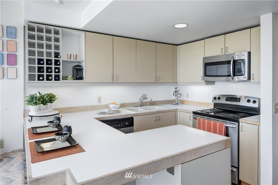 2125 1st Avenue, Unit 1702 Seattle, WA 98121 - Photo 7 of 31 a kitchen with stainless steel appliances a stove a sink and a microwave