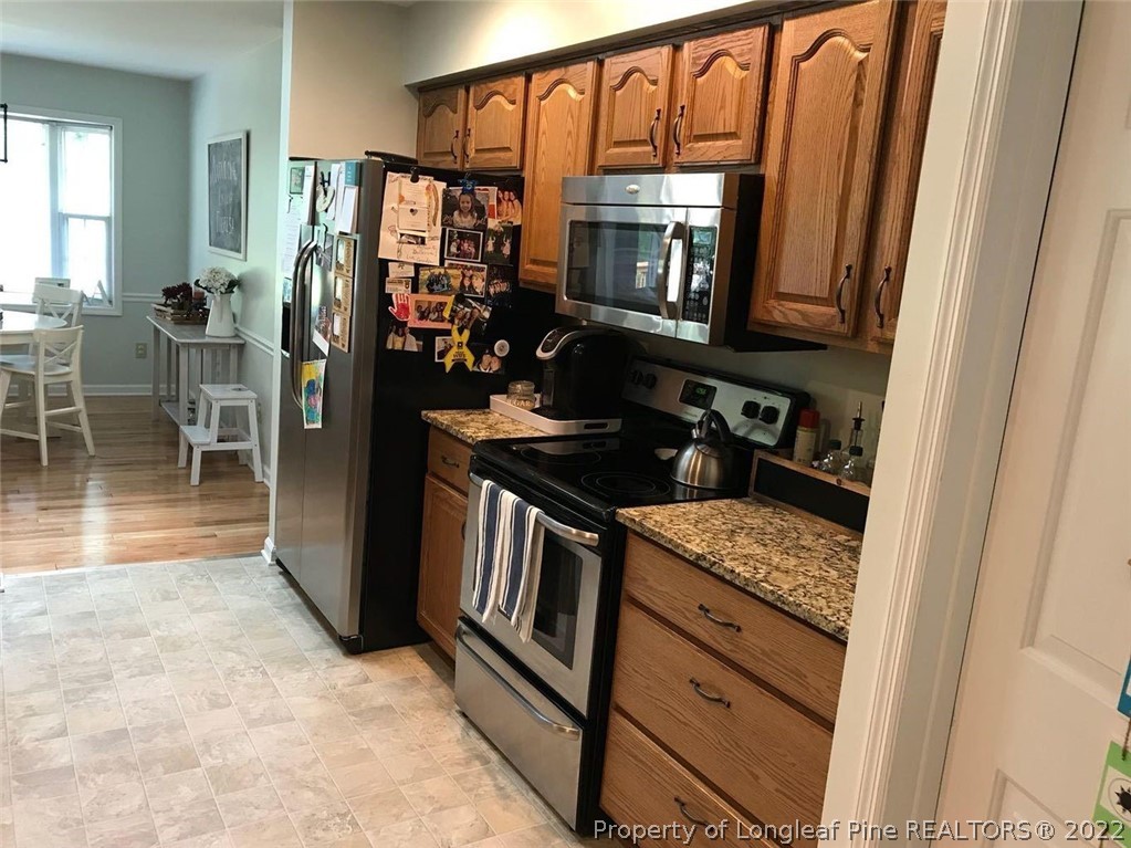21 Princess Gate Whispering Pines, NC 28327 - Photo 12 of 33 a kitchen with granite countertop a refrigerator stove and sink
