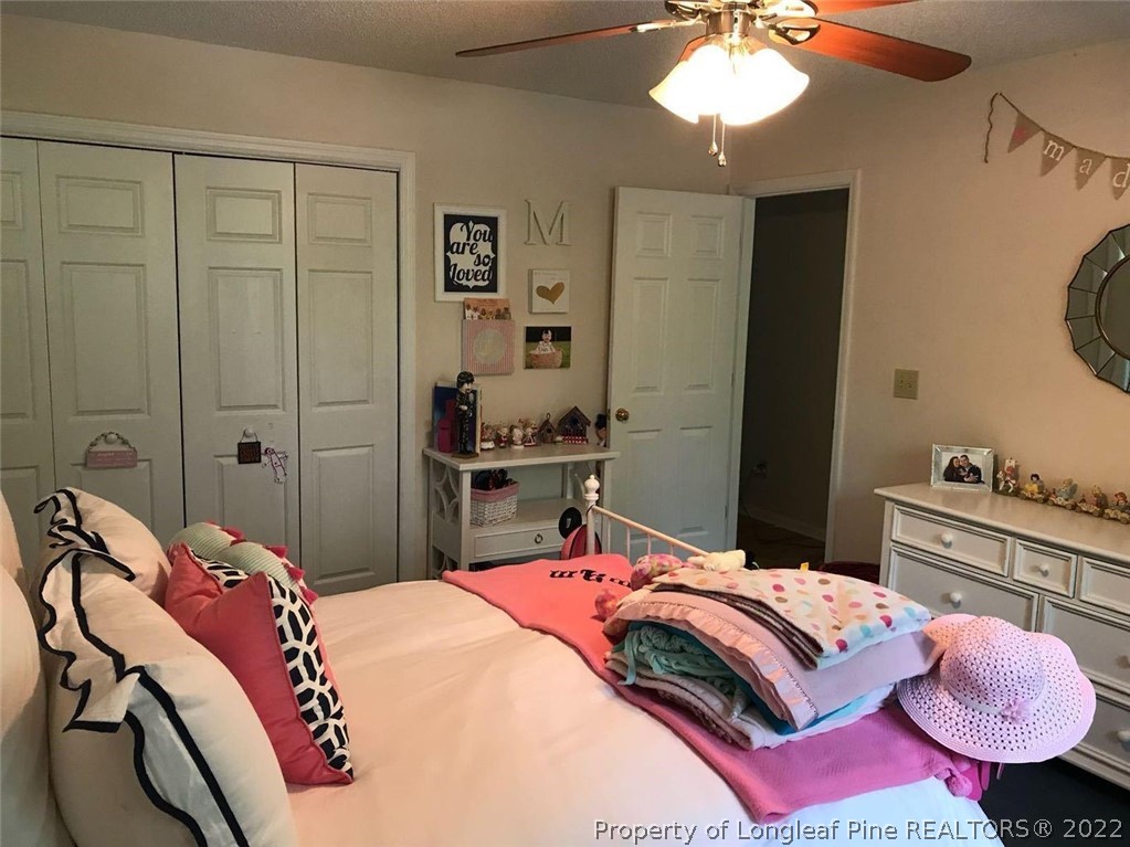 21 Princess Gate Whispering Pines, NC 28327 - Photo 30 of 33 a bedroom with a bed and a chandelier