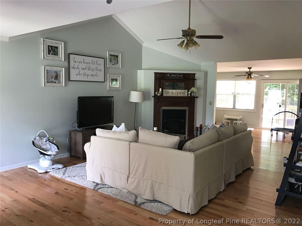 21 Princess Gate Whispering Pines, NC 28327 - Photo 3 of 33 a living room with furniture a fireplace and a flat screen tv