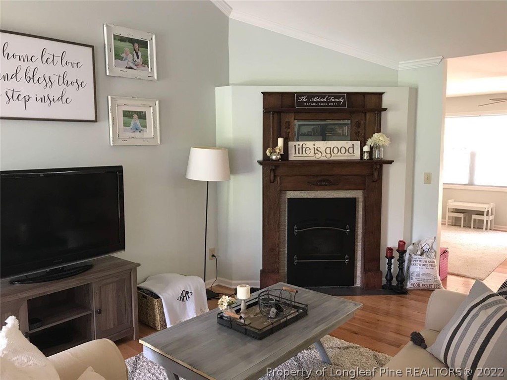 21 Princess Gate Whispering Pines, NC 28327 - Photo 6 of 33 a living room with furniture a flat screen tv and a fireplace