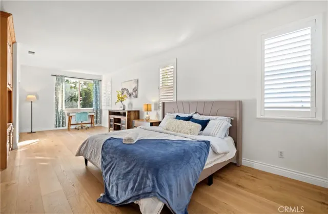 a bedroom with a bed wooden floor and window