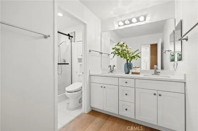 a bathroom with a granite countertop toilet sink and mirror