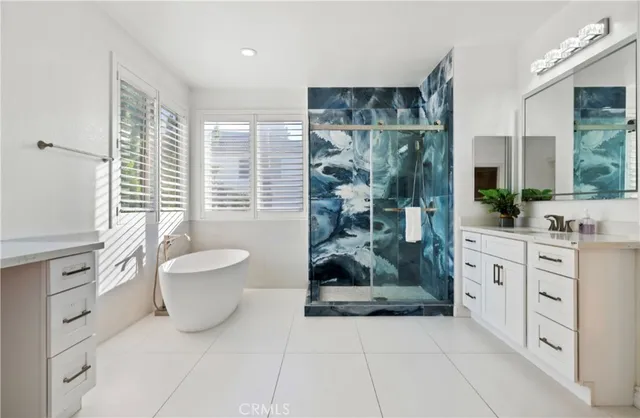 a spacious bathroom with a granite countertop sink a toilet a mirror and a tub