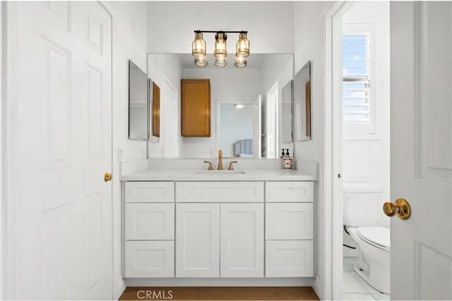 a bathroom with a sink a light fixture and a mirror
