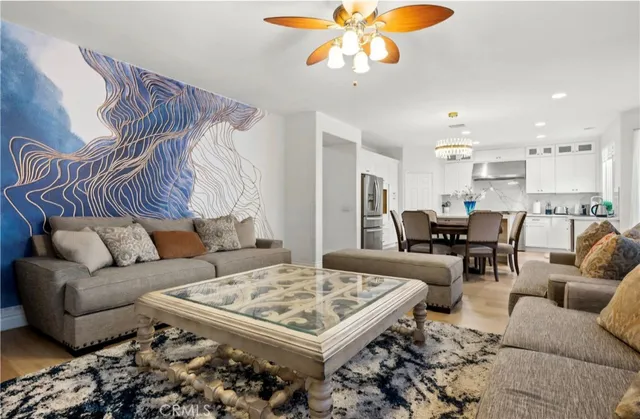 a living room with furniture kitchen view and a chandelier