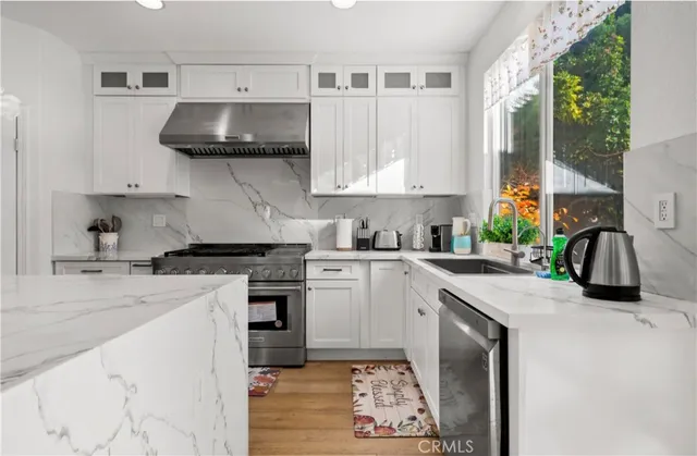 a kitchen with stainless steel appliances a stove a sink and a refrigerator